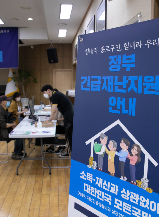 코로나19 위기 극복을 위한 정부의 긴급재난지원금 오프라인 신청 접수 첫 날인 지난 5월 18일 서울 종로구 청운효자동 주민센터에 마련된 접수처에서 시민들이 지원금 신청을 하고 있다. 박동욱기자 fufus@